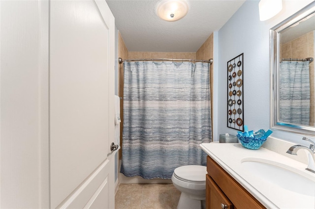 bathroom with tile patterned floors, vanity, a textured ceiling, and toilet