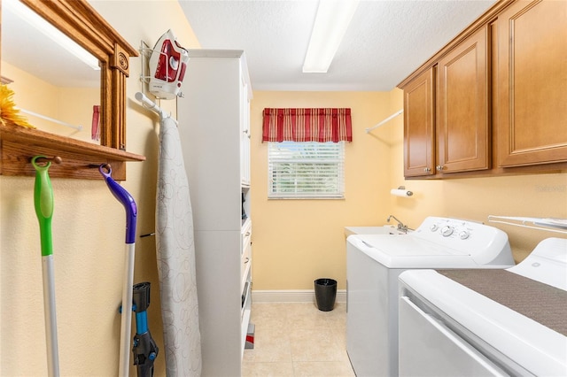 clothes washing area with cabinets, independent washer and dryer, sink, and light tile patterned floors