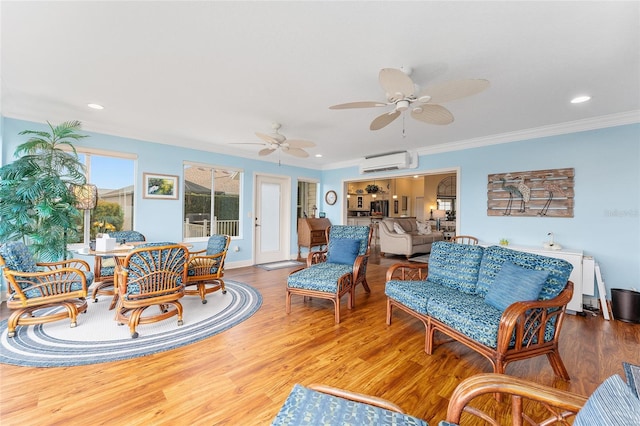 living room with hardwood / wood-style floors, ceiling fan, an AC wall unit, and ornamental molding