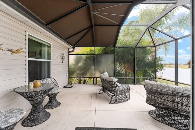 view of patio / terrace with glass enclosure and a water view