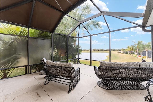 view of patio / terrace featuring a lanai and a water view