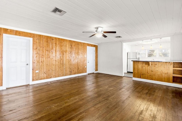 unfurnished living room with dark hardwood / wood-style flooring, wood walls, ceiling fan, wooden ceiling, and crown molding