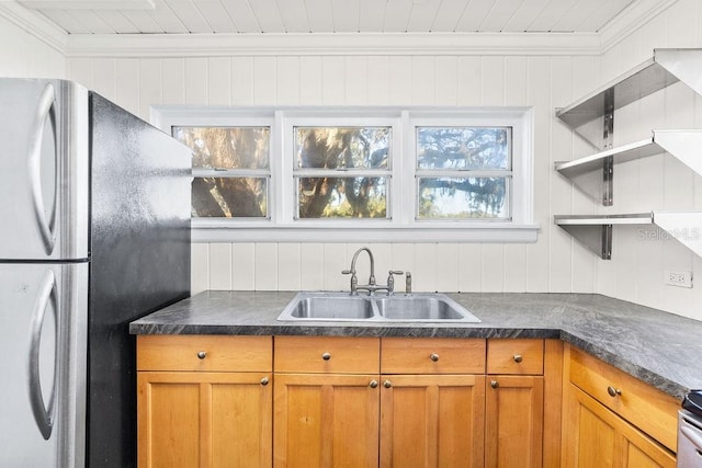 kitchen featuring crown molding, sink, and stainless steel refrigerator