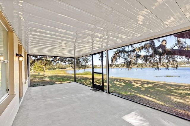 unfurnished sunroom featuring a water view