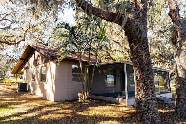 view of side of home with central air condition unit and a sunroom