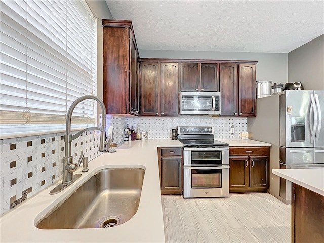 kitchen featuring stainless steel appliances, plenty of natural light, sink, and decorative backsplash