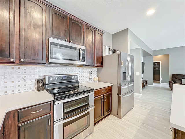 kitchen with tasteful backsplash, appliances with stainless steel finishes, dark brown cabinets, and a textured ceiling