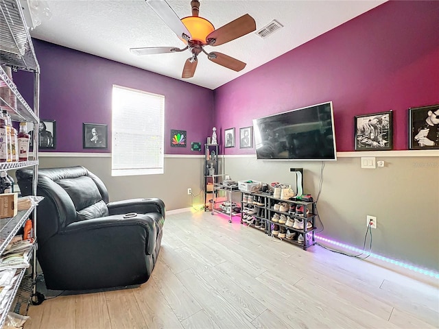 interior space featuring a textured ceiling, light hardwood / wood-style floors, and ceiling fan