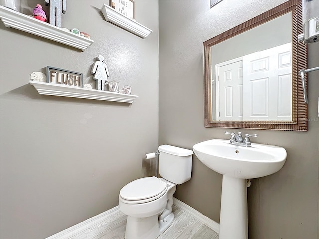 bathroom with sink, toilet, and hardwood / wood-style floors