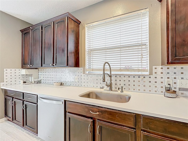 kitchen featuring dark brown cabinetry, sink, backsplash, and dishwasher