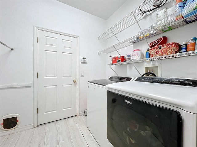 clothes washing area featuring light hardwood / wood-style flooring and washing machine and clothes dryer