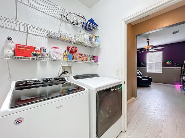 laundry area featuring ceiling fan, washing machine and clothes dryer, and light hardwood / wood-style floors