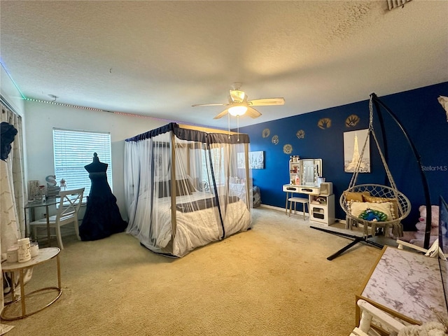 carpeted bedroom featuring multiple windows, a textured ceiling, and ceiling fan