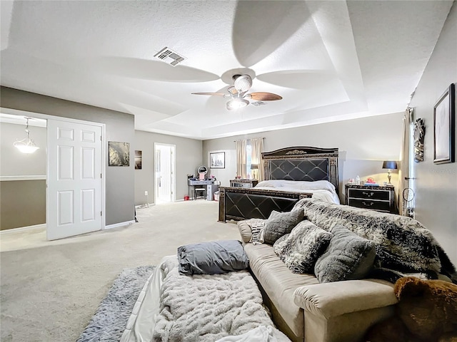 bedroom featuring carpet floors, ceiling fan, and a tray ceiling