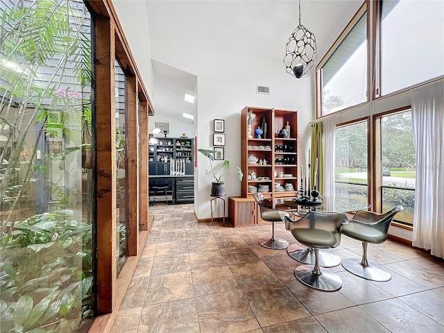 unfurnished dining area featuring a towering ceiling and visible vents