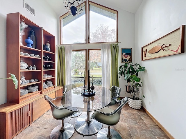 dining space featuring high vaulted ceiling, baseboards, and visible vents