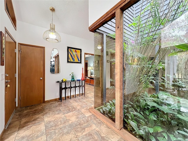 entryway with a textured ceiling and baseboards