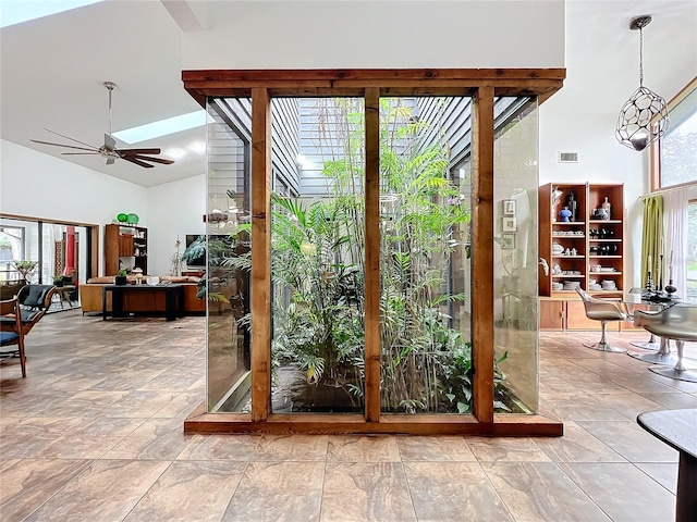 doorway to outside featuring ceiling fan, high vaulted ceiling, visible vents, and a healthy amount of sunlight