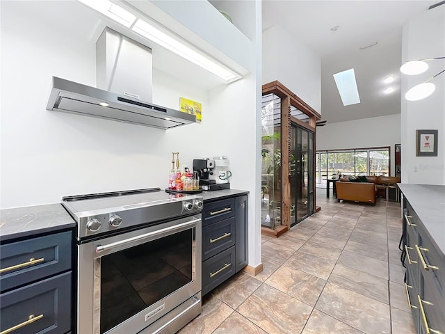 kitchen with wall chimney exhaust hood, stainless steel electric range oven, open floor plan, light stone countertops, and vaulted ceiling