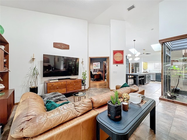 living room featuring a skylight, visible vents, and a high ceiling