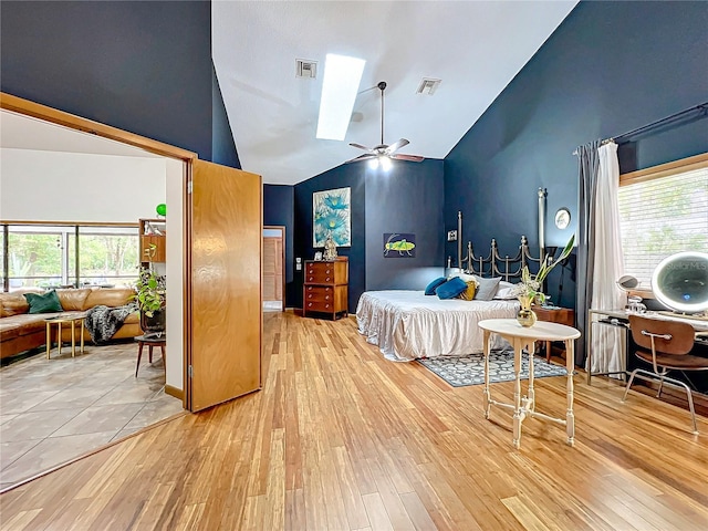 bedroom featuring high vaulted ceiling, visible vents, multiple windows, and wood finished floors