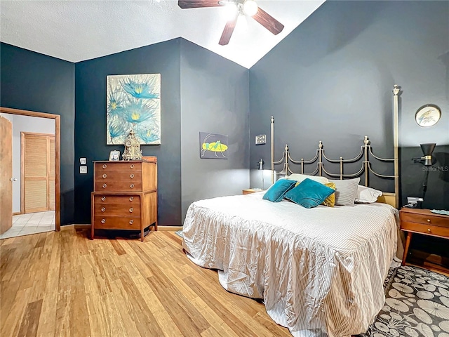 bedroom featuring baseboards, a ceiling fan, vaulted ceiling, and wood finished floors