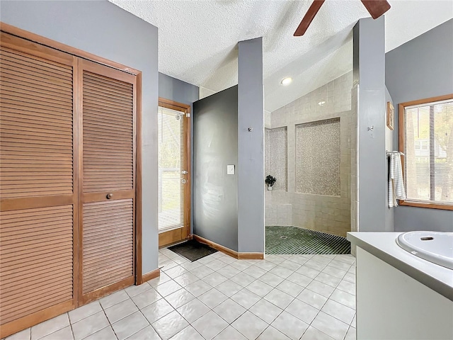 full bathroom featuring a stall shower, a closet, lofted ceiling, and tile patterned floors