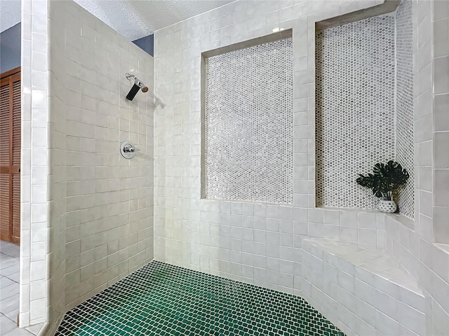 full bath with a tile shower and a textured ceiling