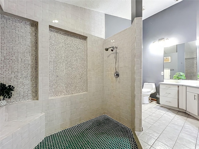 full bathroom with a textured ceiling, tile patterned flooring, toilet, vanity, and a tile shower