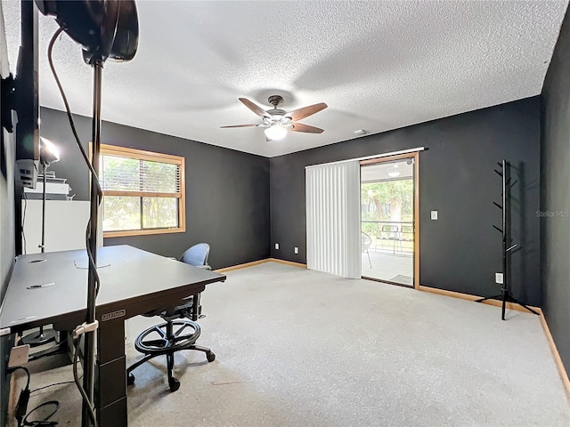 carpeted home office with a textured ceiling, a ceiling fan, and baseboards