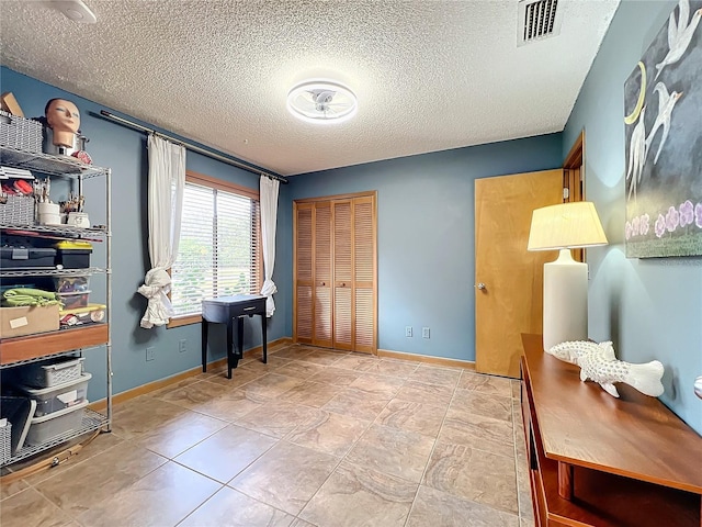 office with baseboards, visible vents, and a textured ceiling