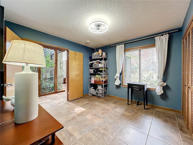 home office with plenty of natural light, baseboards, and a textured ceiling