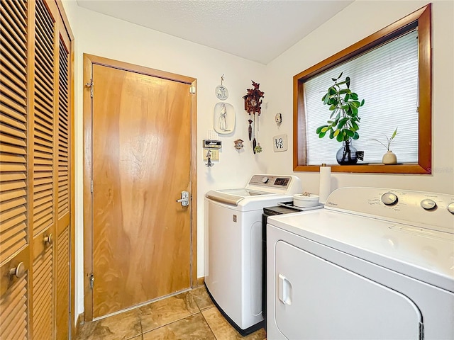 laundry area featuring laundry area, a textured ceiling, and washing machine and clothes dryer