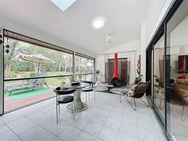 sunroom / solarium featuring lofted ceiling with skylight and ceiling fan