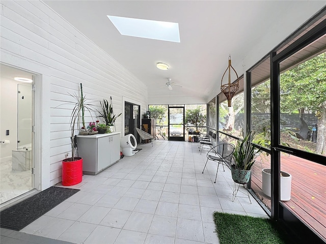 sunroom featuring vaulted ceiling with skylight and ceiling fan