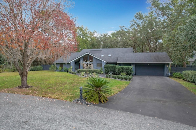 mid-century home with a garage, driveway, and a front lawn