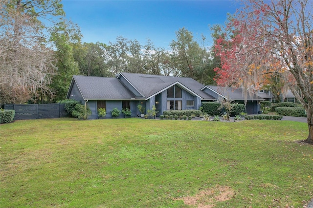 mid-century inspired home with fence and a front lawn