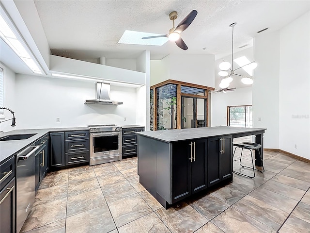 1701 Cedar Stone Ct, Lake Mary, FL 32746 - kitchen with stainless steel appliances, wall chimney range hood, a sink, dark cabinets, and ceiling fan