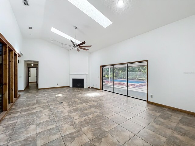 1701 Cedar Stone Ct, Lake Mary, FL 32746 - unfurnished living room with a skylight, high vaulted ceiling, a fireplace, ceiling fan, and baseboards
