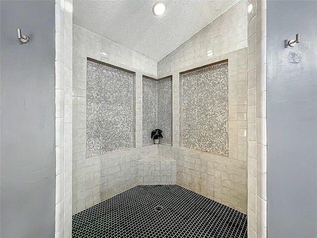 1701 Cedar Stone Ct, Lake Mary, FL 32746 - bathroom with a textured ceiling, tiled shower, and vaulted ceiling