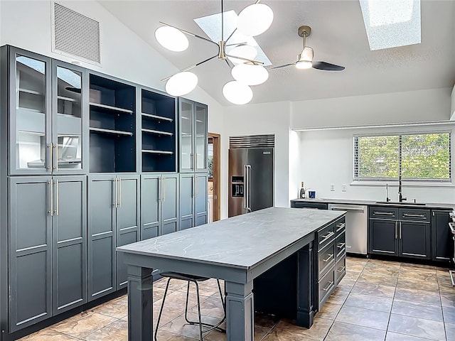 1701 Cedar Stone Ct, Lake Mary, FL 32746 - kitchen with appliances with stainless steel finishes, a sink, lofted ceiling, a skylight, and a kitchen island