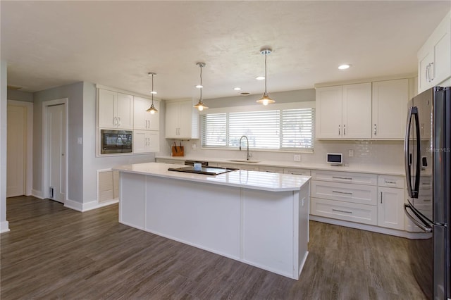 kitchen featuring a center island, stainless steel fridge, white cabinets, and sink