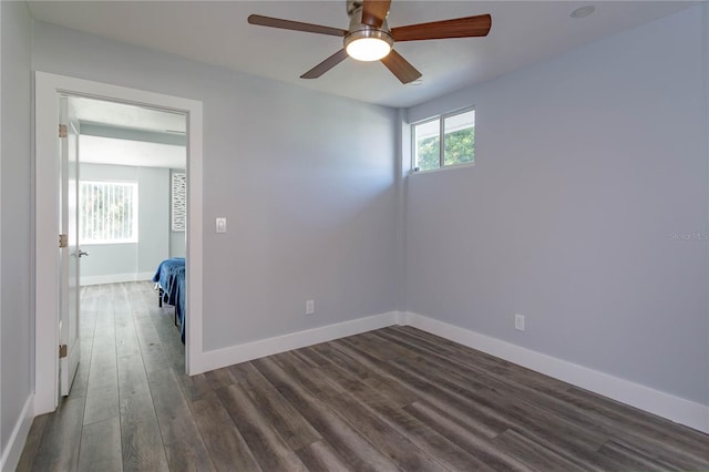 empty room with ceiling fan and dark wood-type flooring