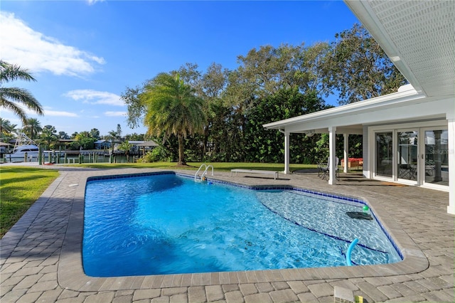 view of pool featuring a water view and a patio area