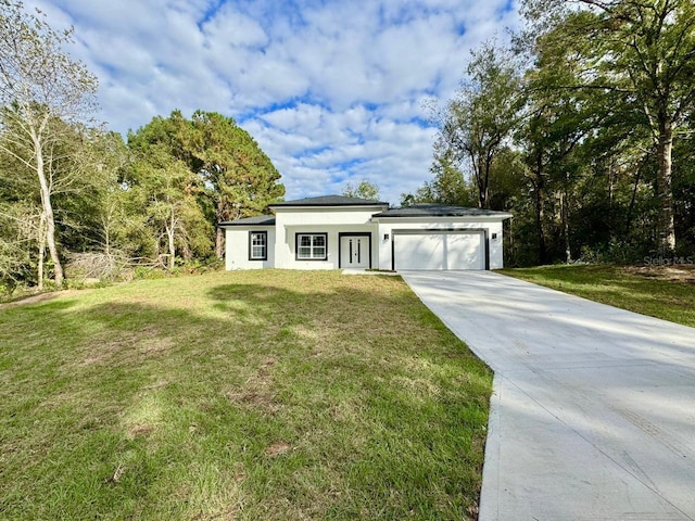 view of front of property with a garage and a front lawn