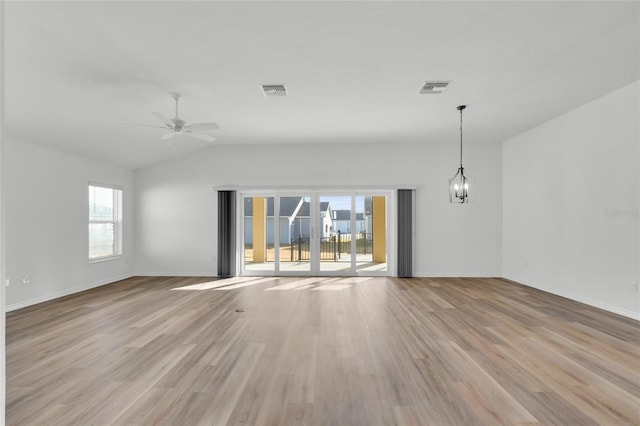 interior space with lofted ceiling, ceiling fan with notable chandelier, and light hardwood / wood-style flooring