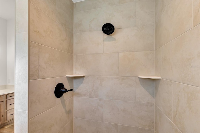 room details with vanity and a tile shower