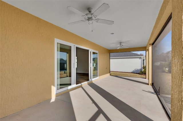 unfurnished sunroom with ceiling fan