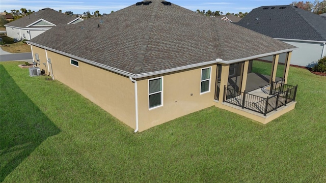 rear view of property featuring a patio area, central air condition unit, and a lawn