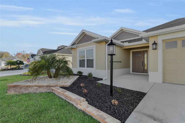 property entrance with a garage and a lawn